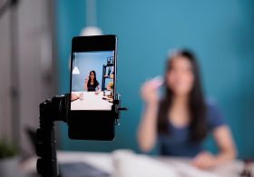 scene-beauty-influencer-recording-makeup-brush-review-filming-tutorial-with-smarphone-camera-studio-content-creator-vlogging-cosmetic-podcast-social-media-channel-close-up.jpg